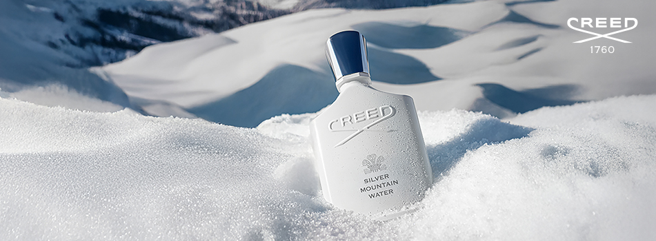 Creed Silver Mountain Water Parfumflakon in schneebedeckter Berglandschaft, weißer Flakon mit silbernem Verschluss, inspiriert von klarer Bergluft und frischem Schnee